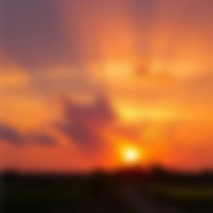 A vibrant sunset displaying shades of orange, yellow, and pink with the sun partially hidden behind the horizon.