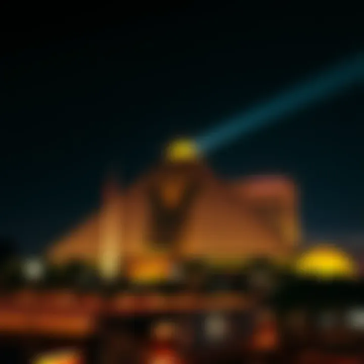 The Luxor Hotel illuminated at night, showcasing its pyramid shape with a bright light beam shining from the top, surrounded by a dark sky.