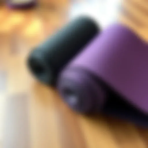 Two yoga mats, Manduka Pro and Prolite, side by side on a wooden floor, showcasing their different textures and colors.