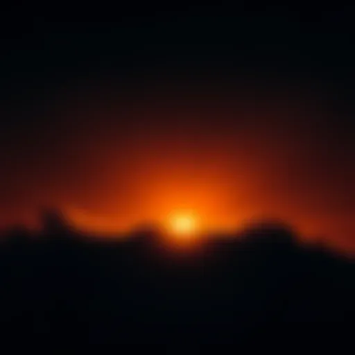 A bright orange light shining in the night sky above Hickory, NC, partially obscured by clouds.