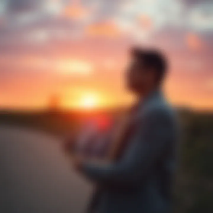A person stands outdoors, holding a picture of their deceased father, looking reflective and emotional, with a sunset in the background.