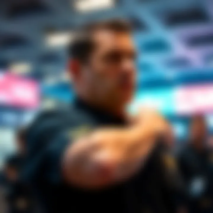 A security guard in a black shirt taps his upper arm while looking around, appearing to give a signal in the Charlie Kirk incident.