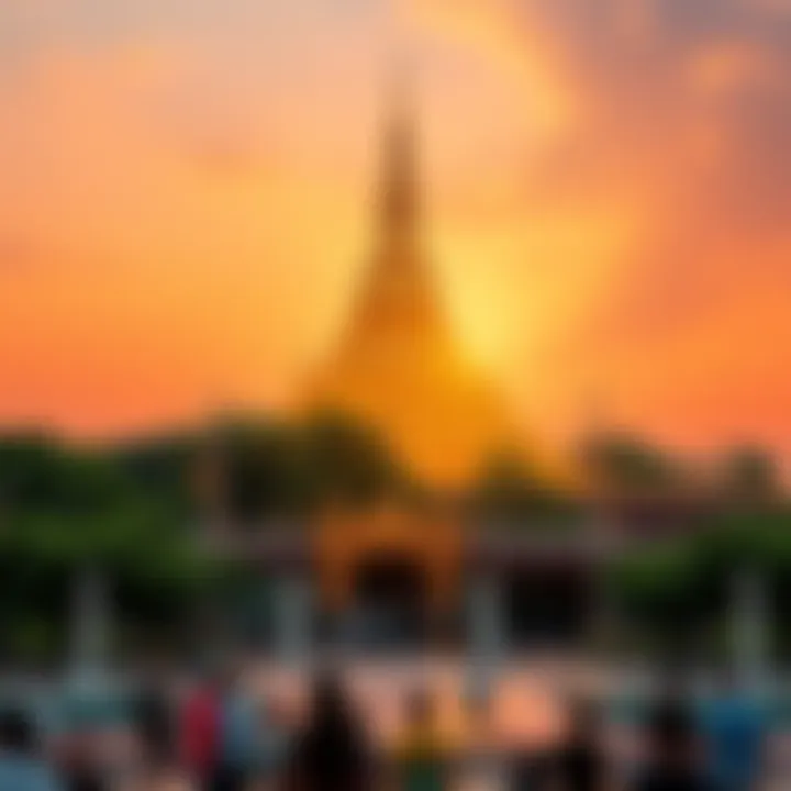 The golden Shwedagon Pagoda shines brightly against a sunset sky, surrounded by lush greenery and visitors admiring its beauty.