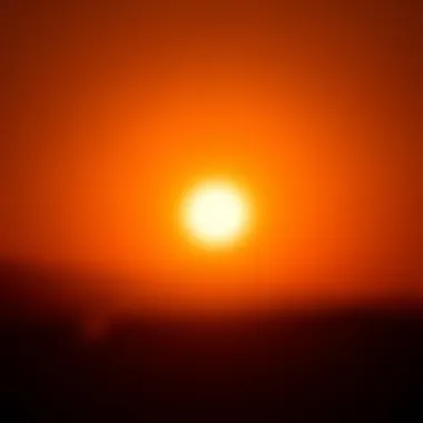 Sun Over Horizon A bright orange sun rising above the horizon with rays spreading out