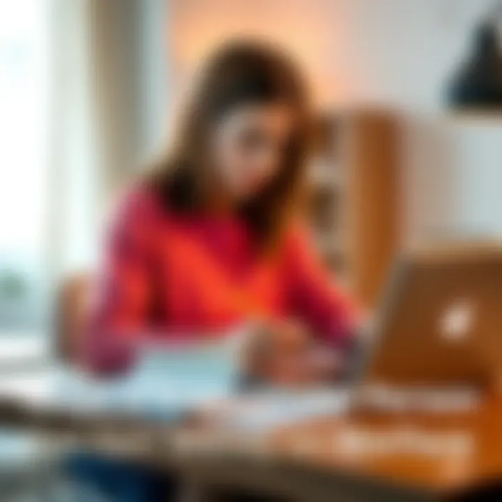 A transgender person sitting at a desk with a laptop, writing notes and looking focused, symbolizing job searching and financial planning.